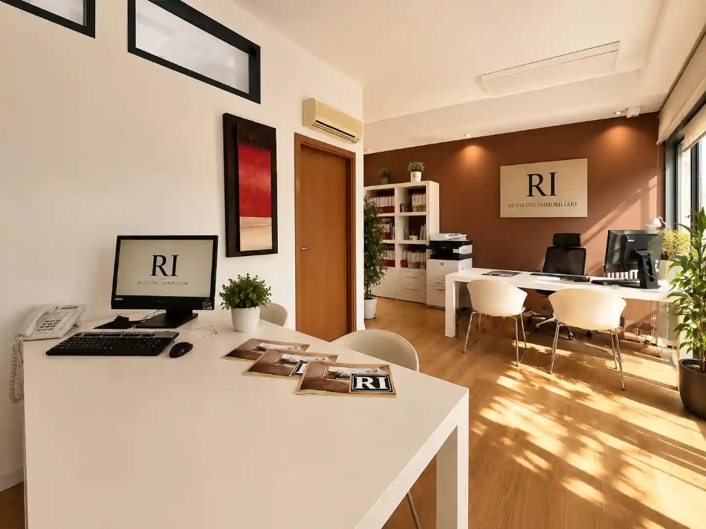 Interno sede Righetto Immobiliare a Limena — area lavoro, logo e materiali istituzionali